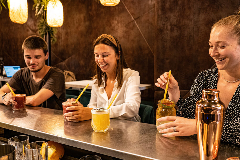 personnes qui boivent un cocktail avec une paille en pâte personnalisée dans un bar